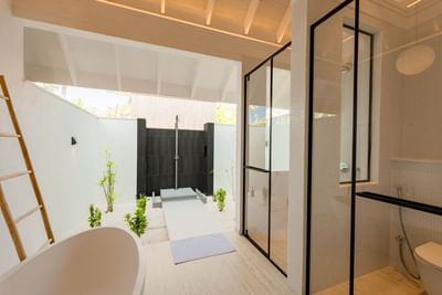 Modern 2-Bedroom Beach Villas bathroom at Ananea Madivaru Maldives with a bathtub, black outdoor shower, and natural light