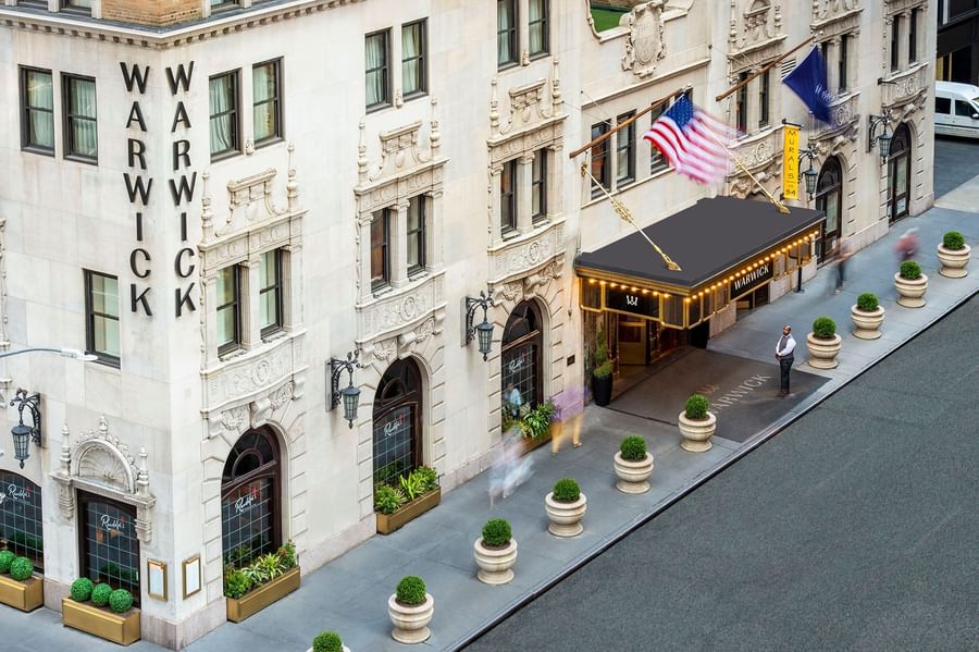 High-angle view of the Warwick New York entrance featuring a black awning and flags