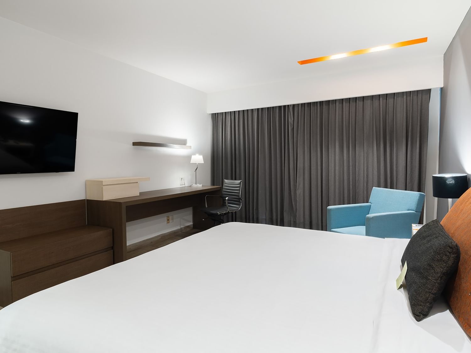 Habitación de lujo con cama King, televisor, escritorio y silla en Real Inn Perinorte, Tlalnepantla.