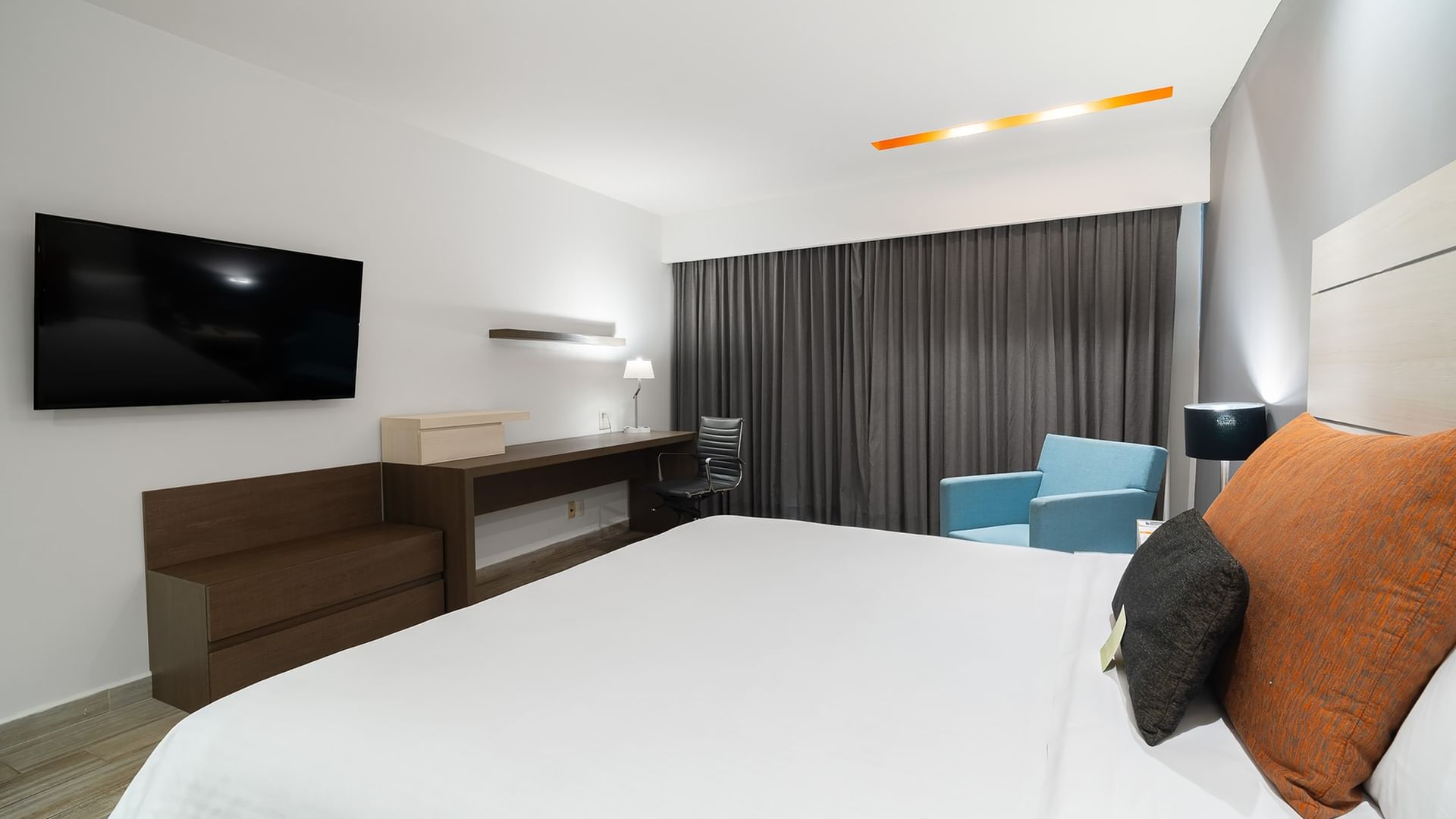 Habitación de lujo con cama King, televisor, escritorio y silla en Real Inn Perinorte, Tlalnepantla.