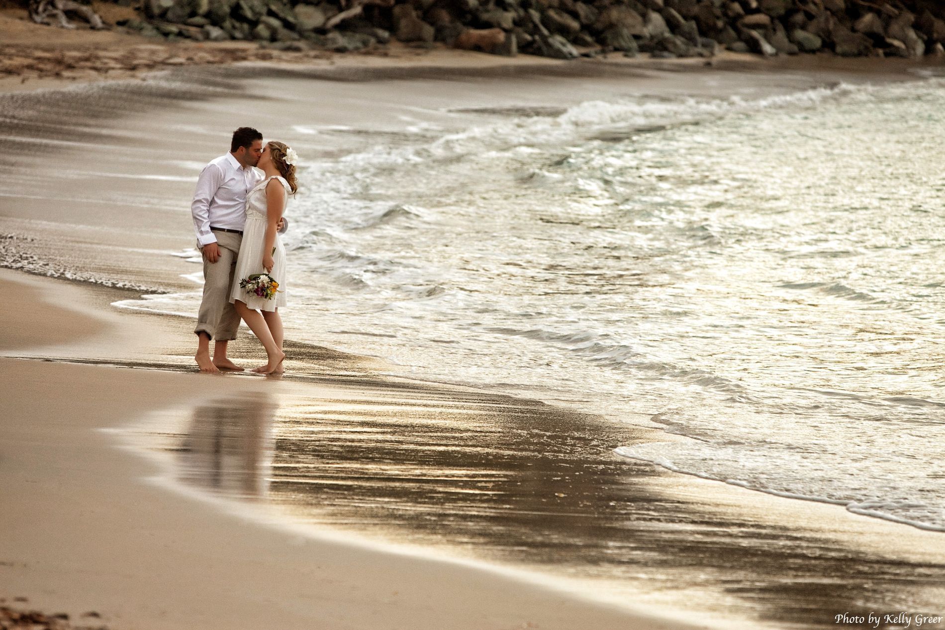 A wedding couple kissing on Whistle Beach near Buccaneer Hotel