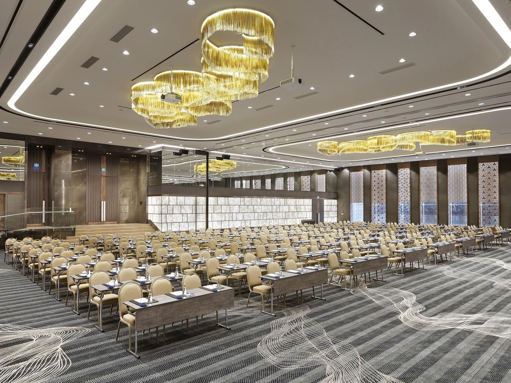 Titanic Business Kartal’daki Karina salonunda, masa ve sandalyelerle düzenlenmiş tiyatro tipi büyük etkinlik alanı