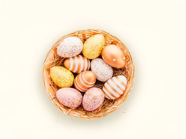 A woven basket of metallic and speckled Easter eggs, shining in shades of gold and pink at Hacienda del Mar Los Cabos