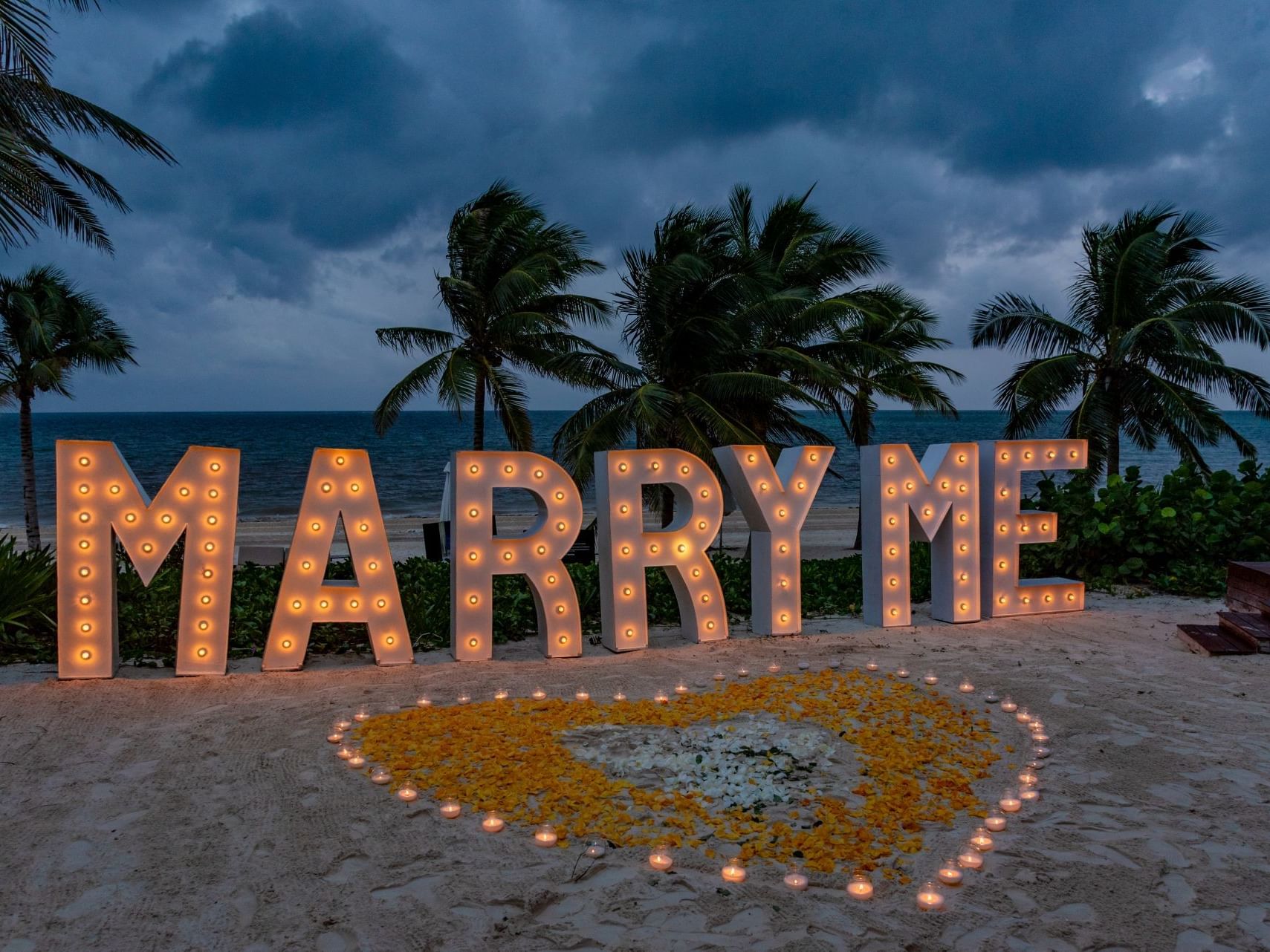Marry me sign with palm trees & beach in the background at Haven Riviera Cancun