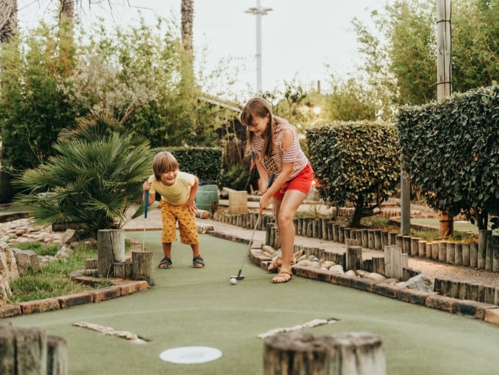 two children playing putt putt golf