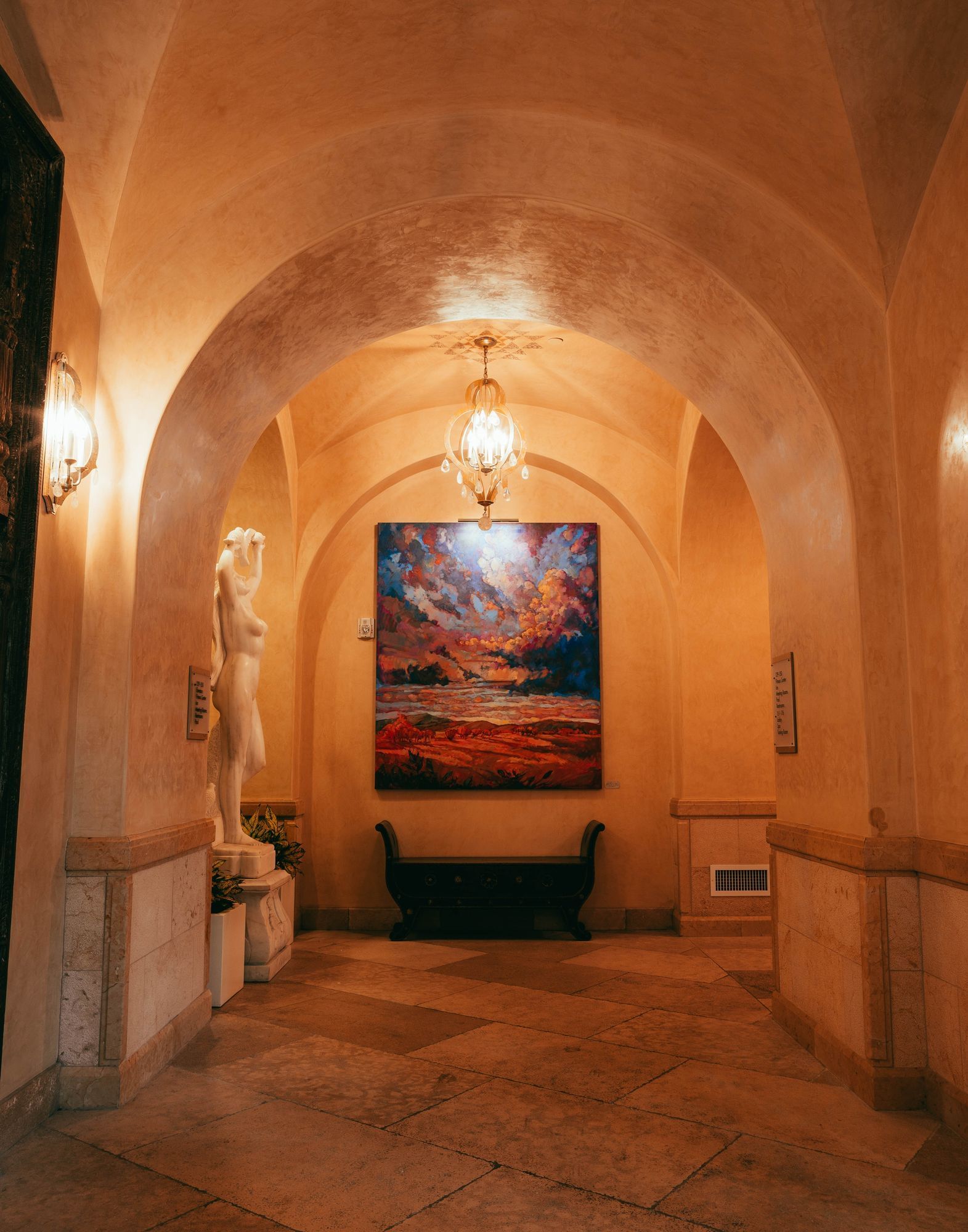 Lorem ipsum Arched hallways with painting and bench at the end
