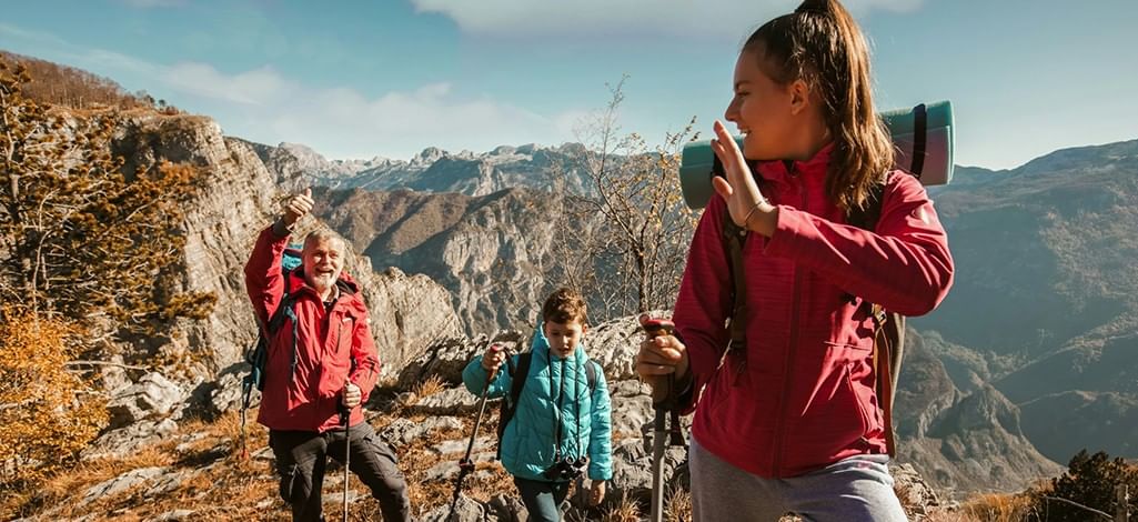 A person enjoys a short hike with their child and parent on a beautiful fall day in Canmore.