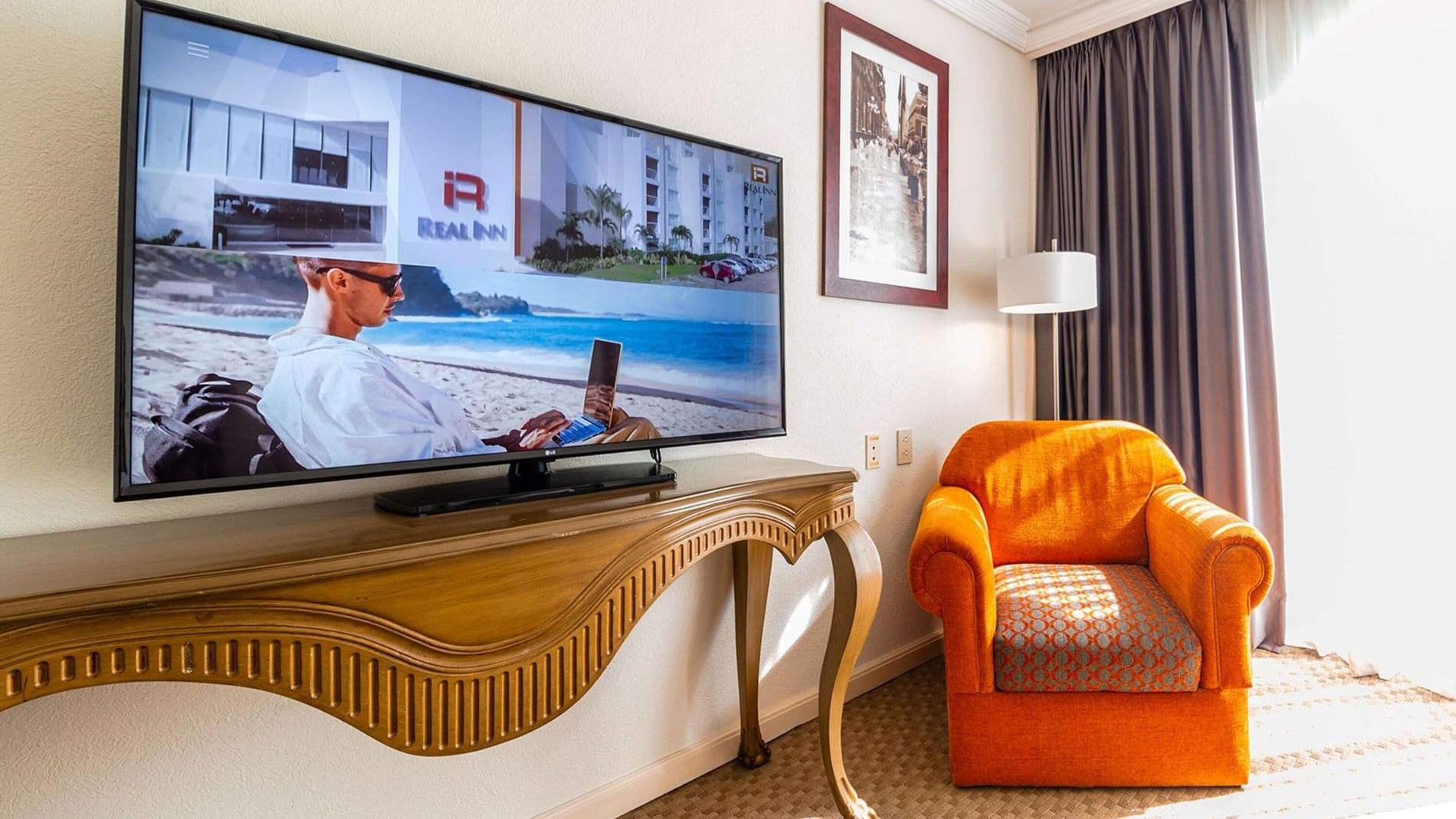 2 Double Camino Real Club featuring Large flatscreen TV on a console near an orange chair at Camino Real Puebla Angelopolis