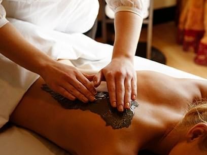 Lady receiving a scrub treatment in Sun Tree Spa at Temple Gardens Hotel & Spa