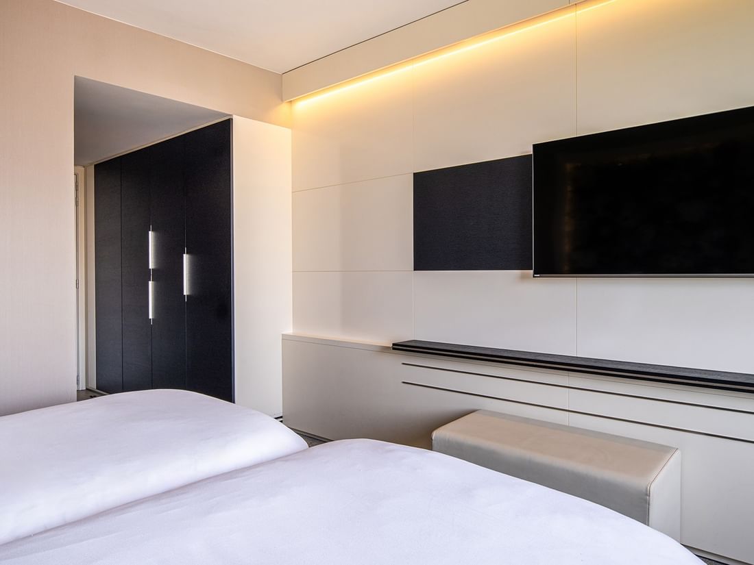 Wall-mounted TV facing twin beds and a wardrobe in the Superior Twin at The Hotel Brussels