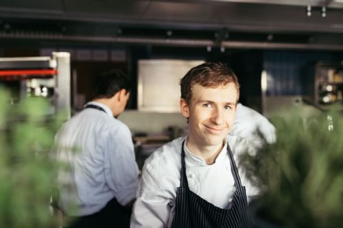 A chef posing in a restaurant's kitchen at Liebes Rot Flueh