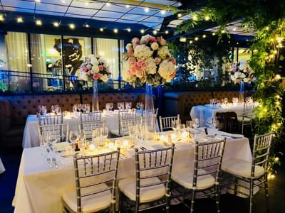 Floral dining tables arranged in Tony's at J House Greenwich, a romantic hotel in Greenwich with fine dining restaurant