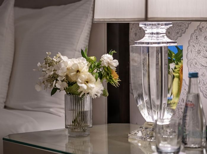 Close up of fresh white flowers in a glass vase on a luxury bedside table at Warwick New York