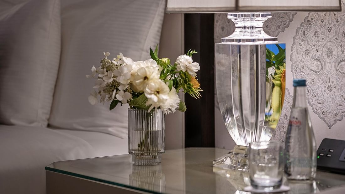 Elegance of Premier Room with white pillows and a floral centerpiece at Warwick New York