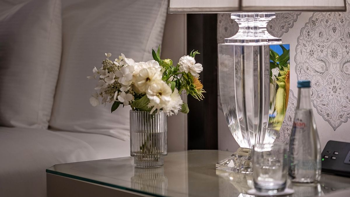 Elegance of Premier Room with white pillows and a floral centerpiece at Warwick New York