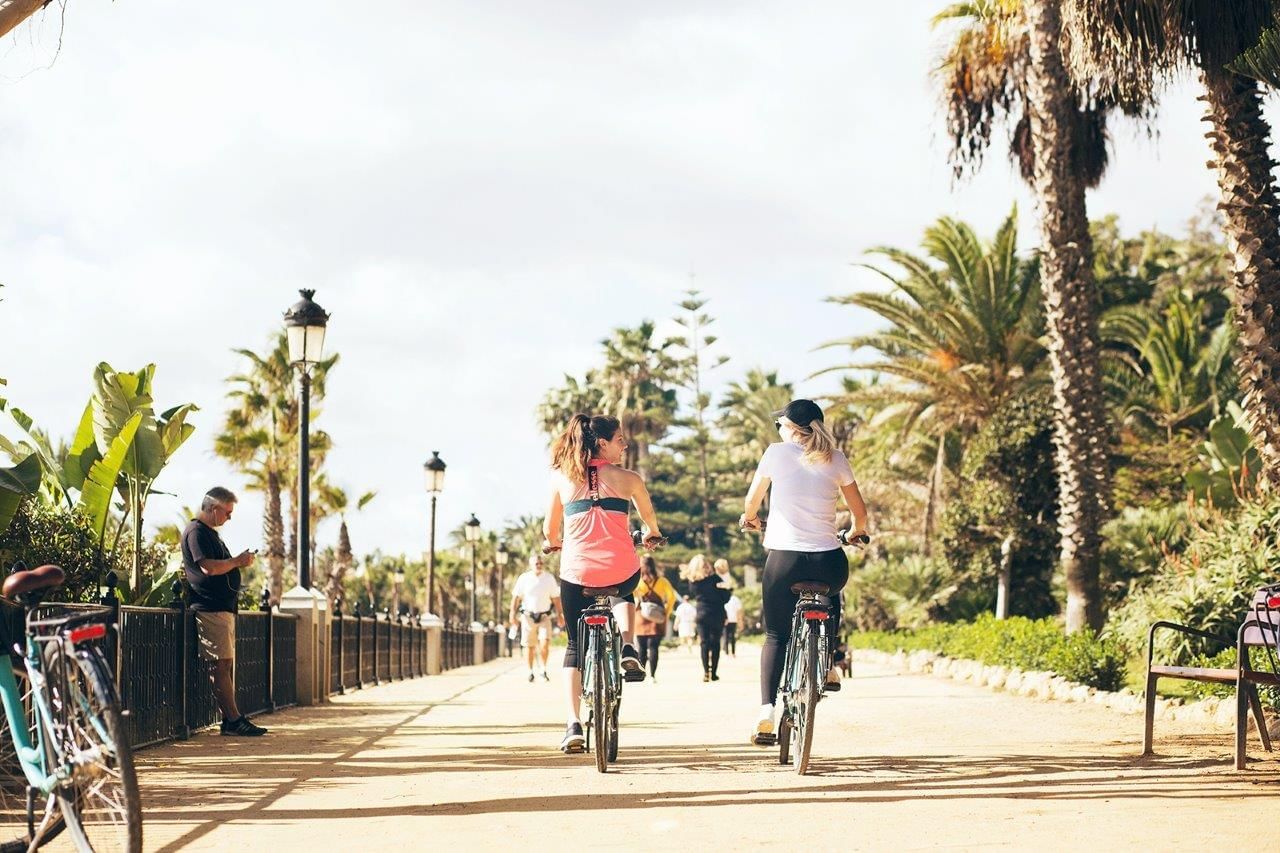 Women riding a bycicle in the promenade