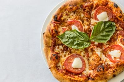 Homemade pizza served with a garnish at Heritage House Resort