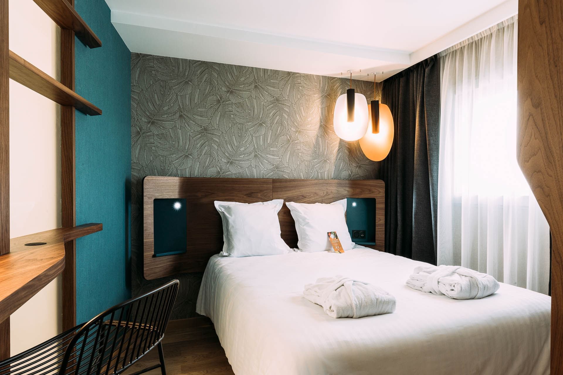 Lit confortable avec fenêtre à l'Oceania Paris Porte de Versailles