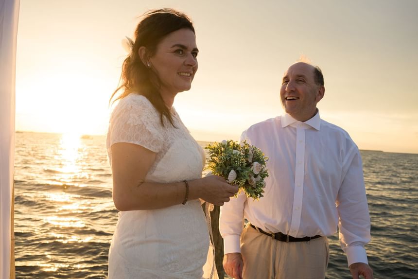 Bride and groom posing for picture happily surrounded by the sunset at Bayside Inn Key Largo