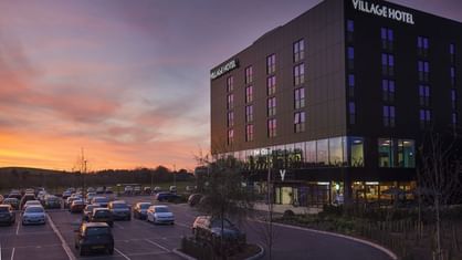 An exterior view of the hotel & car park at Village Hotels