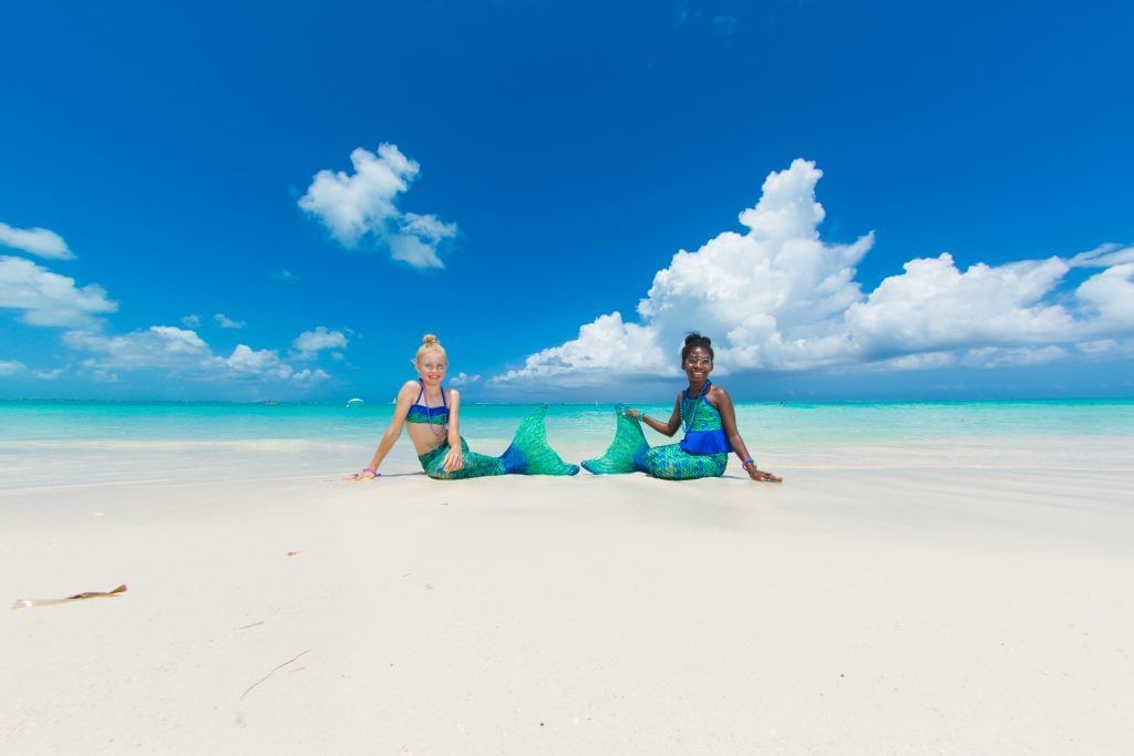 Two girls facing for a photograph near The Somerset on Grace Bay