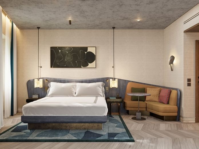 Modern guest room with one queen bed, pendant lighting, seating area, and contemporary artwork at The Thompson Rome.