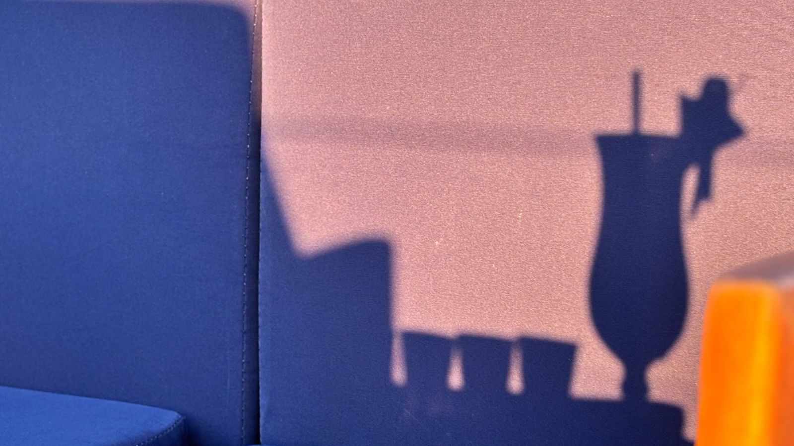 Blue seating with a drink and umbrella shadow at The Naviti Resort in Korolevu.