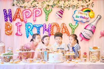 Children enjoying a party with colorful decorations, party hats and treats in a cheerful event space at Park Hotel Hong Kong