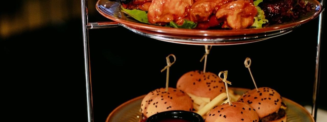 Two-tiered platter with ribs, chicken, sliders, and fries for NRL Game Day Graze.