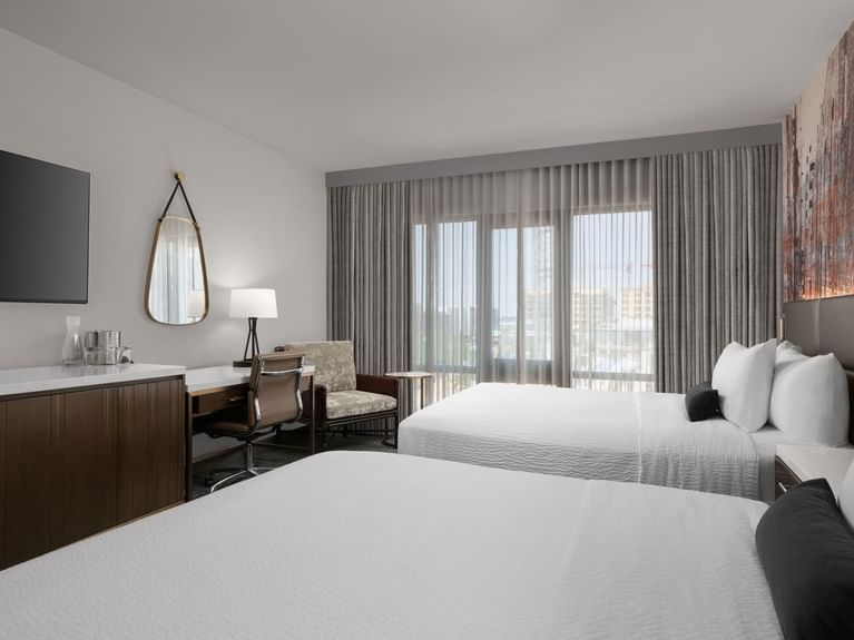 Boutique Double Queen room with two queen beds, a TV, and a chair at Hotel 43 Boise