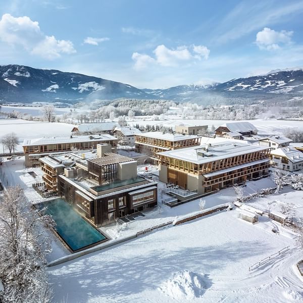 Aerial view of Falkensteiner Hotel Kronplatz surrounded by snowy mountains and fields