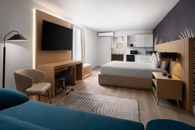 Accessible Mini Suite King with wooden desk, wall-mounted TV, and small kitchenette at The Harrison Hotel Downtown Hollywood