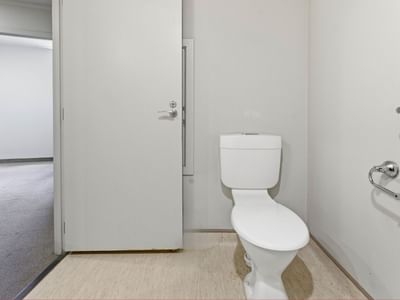 White toilet in a clean bathroom with white walls and flooring at UniLodge Stafford House.