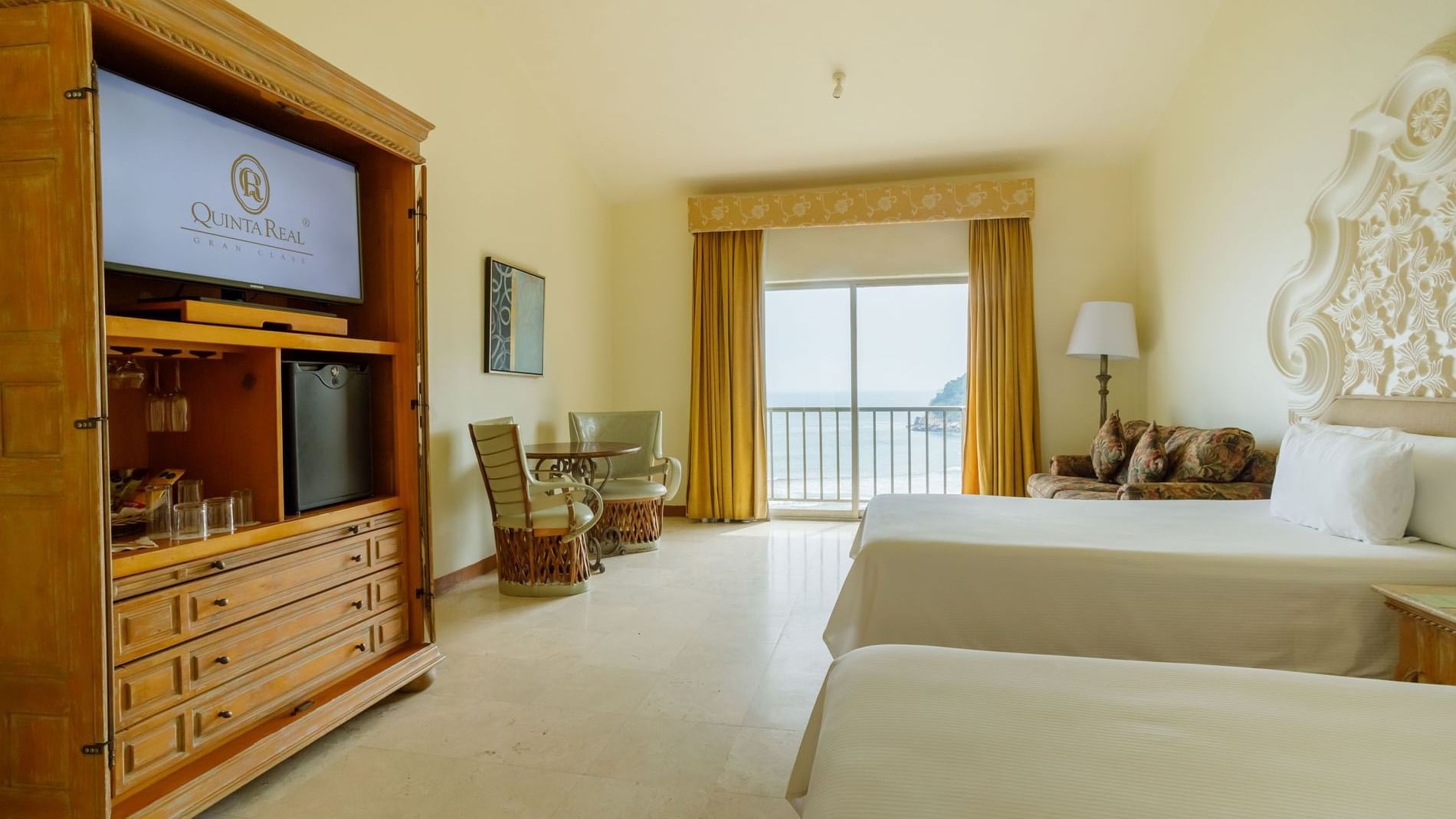 2 Double Grand Class showing a classic wooden TV cabinet and views of the Pacific coast at Quinta Real Acapulco