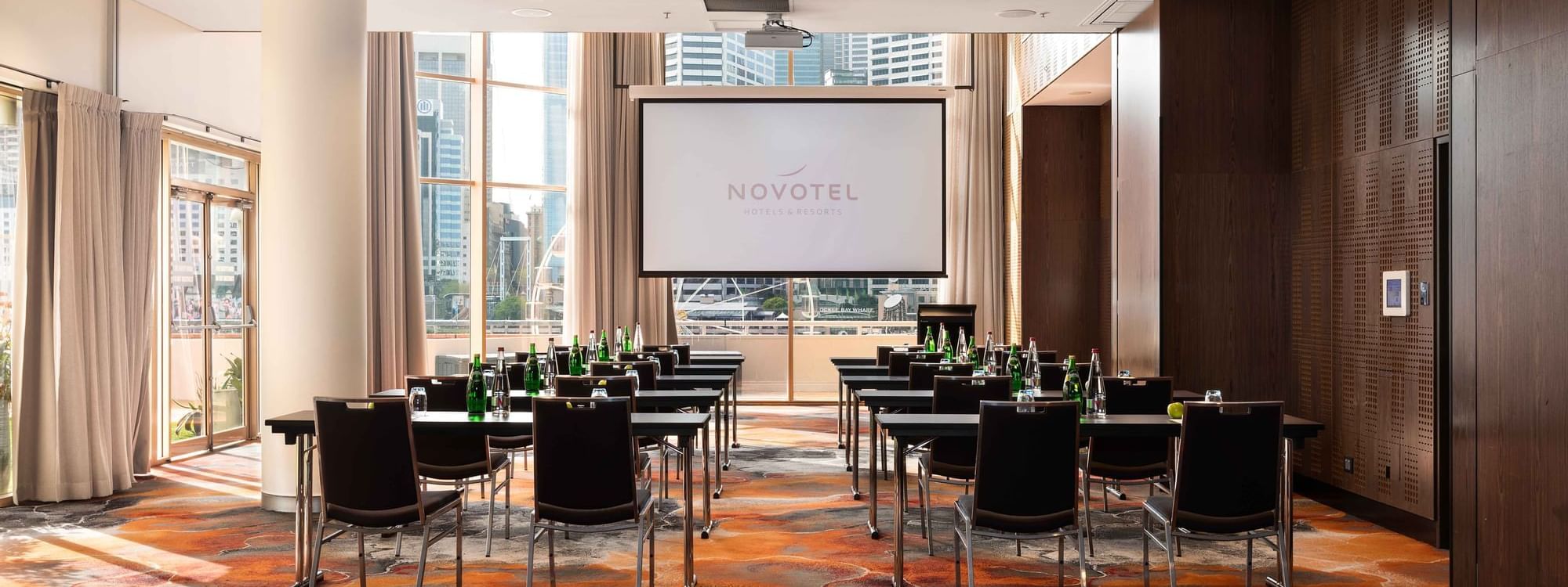 Classroom set up facing the projector screen in The Hunter Room 1 at Novotel Sydney on Darling Harbour
