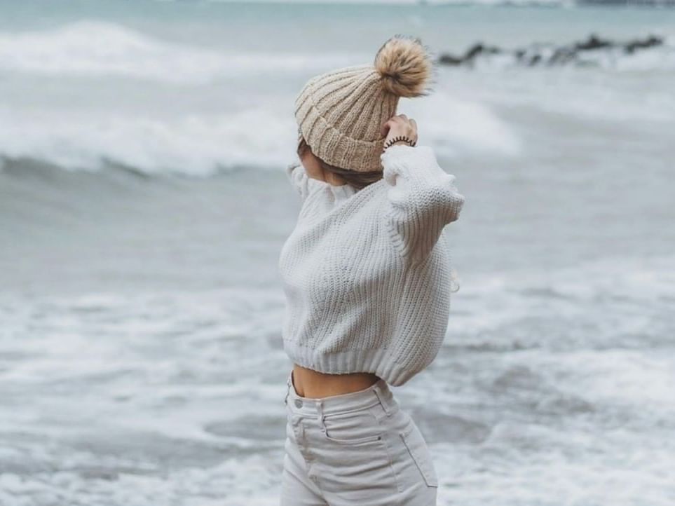 Woman in winter hat on the beach