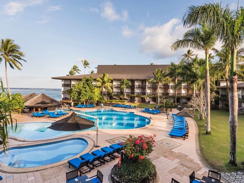 View of the outdoor swimming pool & hotel at Warwick Fiji