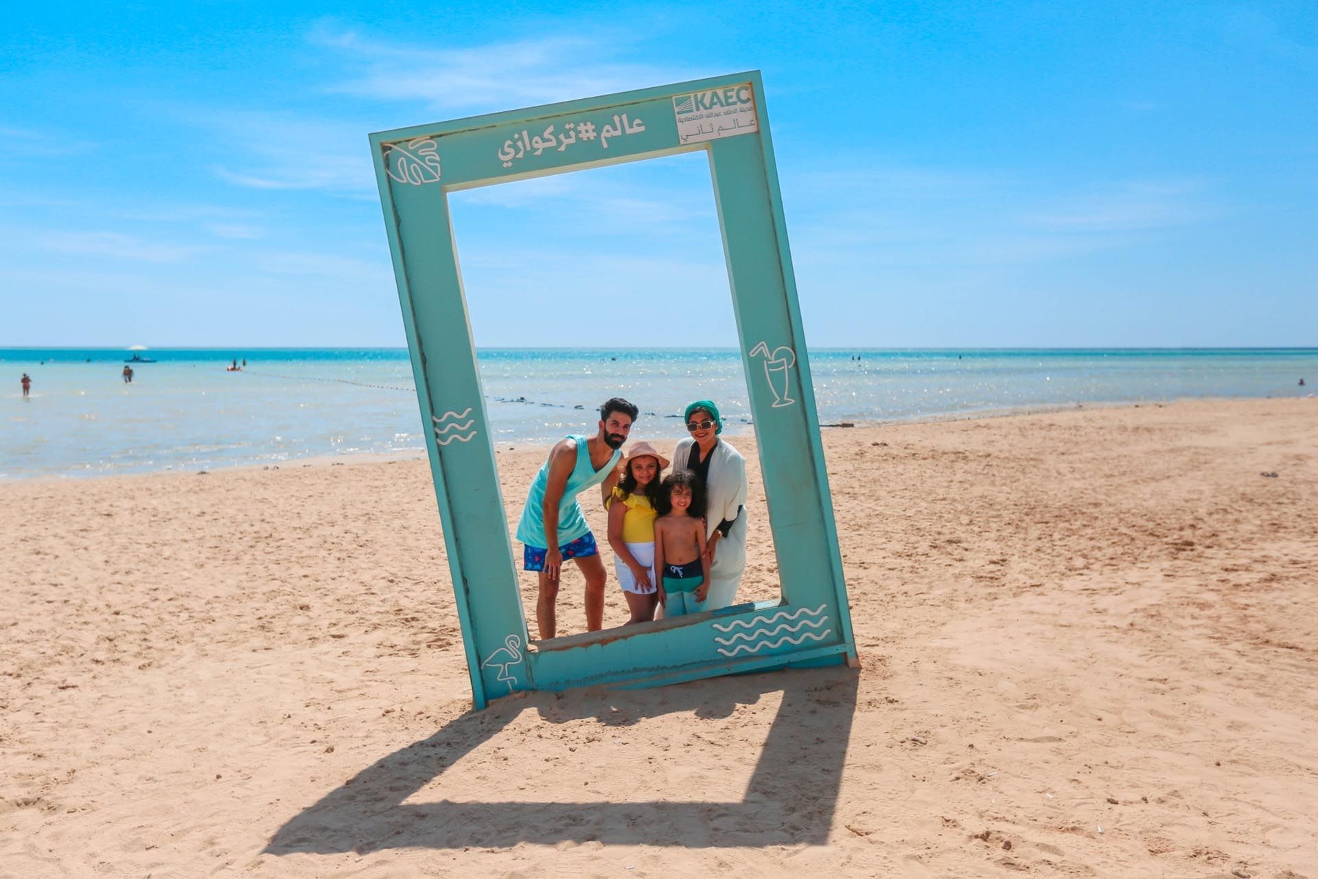A family posing for a photo by the beach near Bay La Sun Hotel