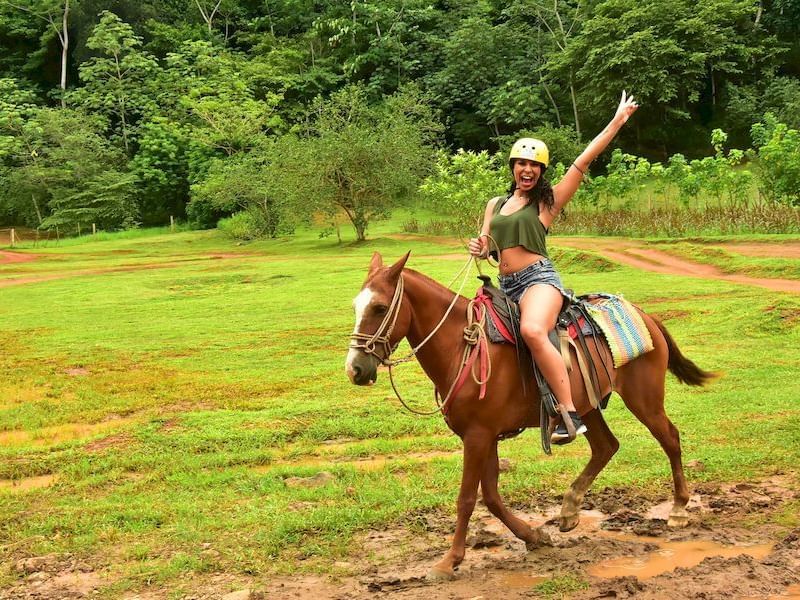 Woman riding a horse in a mud puddle near Los Altos Resort