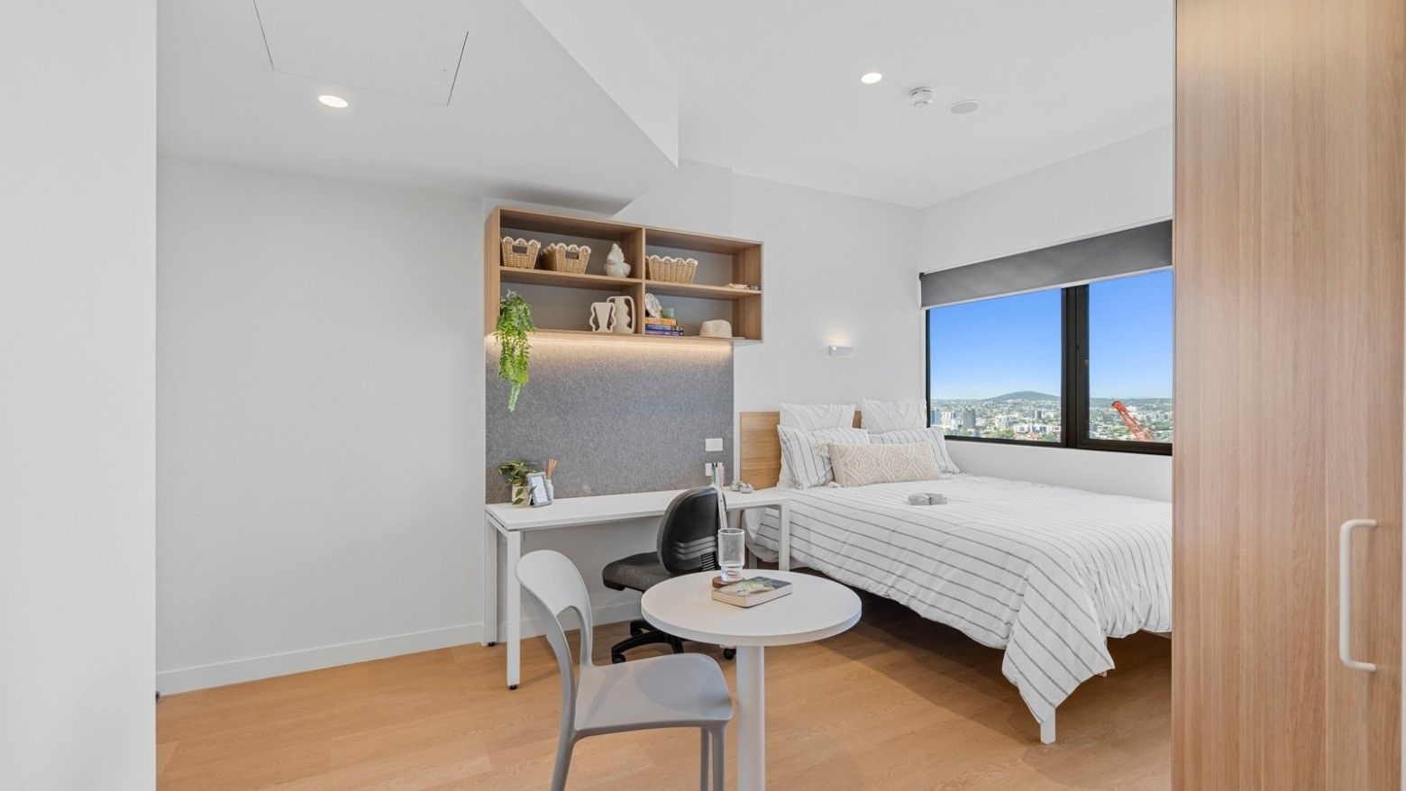 Clean modern bedroom with desk and city view at UniLodge Brisbane City.