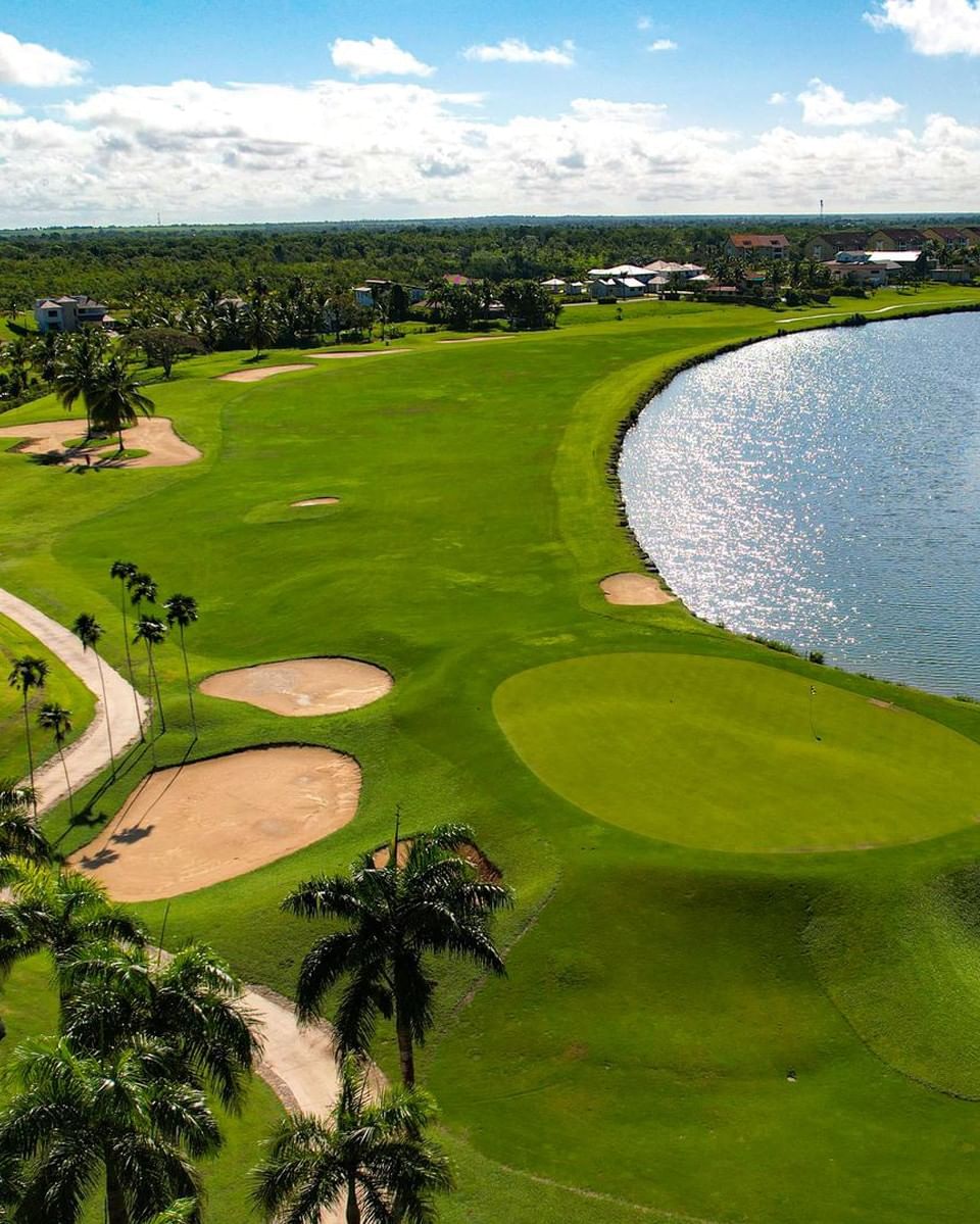 Aerial view of the lush green golf course at The Hub at Estancia, including a winding water hazard and sand traps