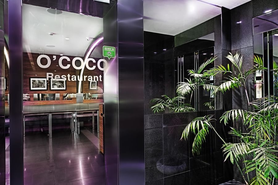 O'cocco Restaurant entrance by green plants under purple neon lights at Warwick Stone 55 - Beirut