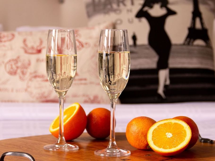 Two wine glasses & oranges served on a table at Retro Suites Hotel