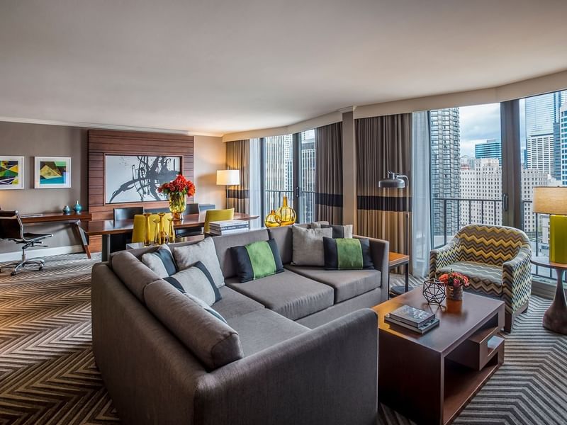 Living area featuring a grey sofa by a wooden coffee table inEmerald Suite (1908) at Warwick Seattle