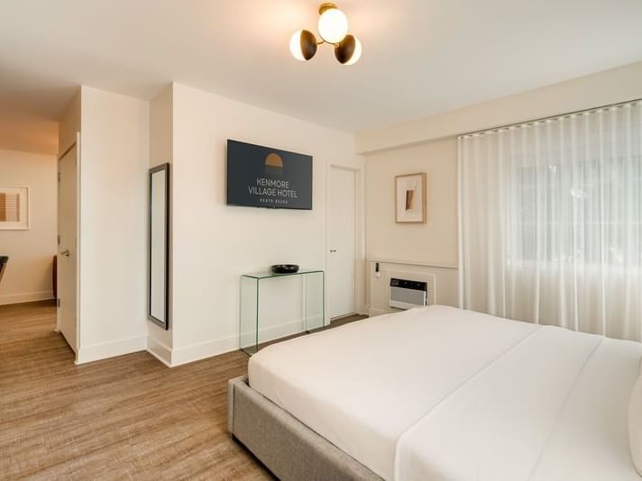 One Bedroom Suite King with a bed, glass console, and TV at Kenmore Village Hotel, among the best South Beach hotels