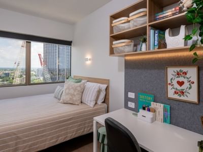 Cozy bedroom with desk and city view at UniLodge Brisbane City.
