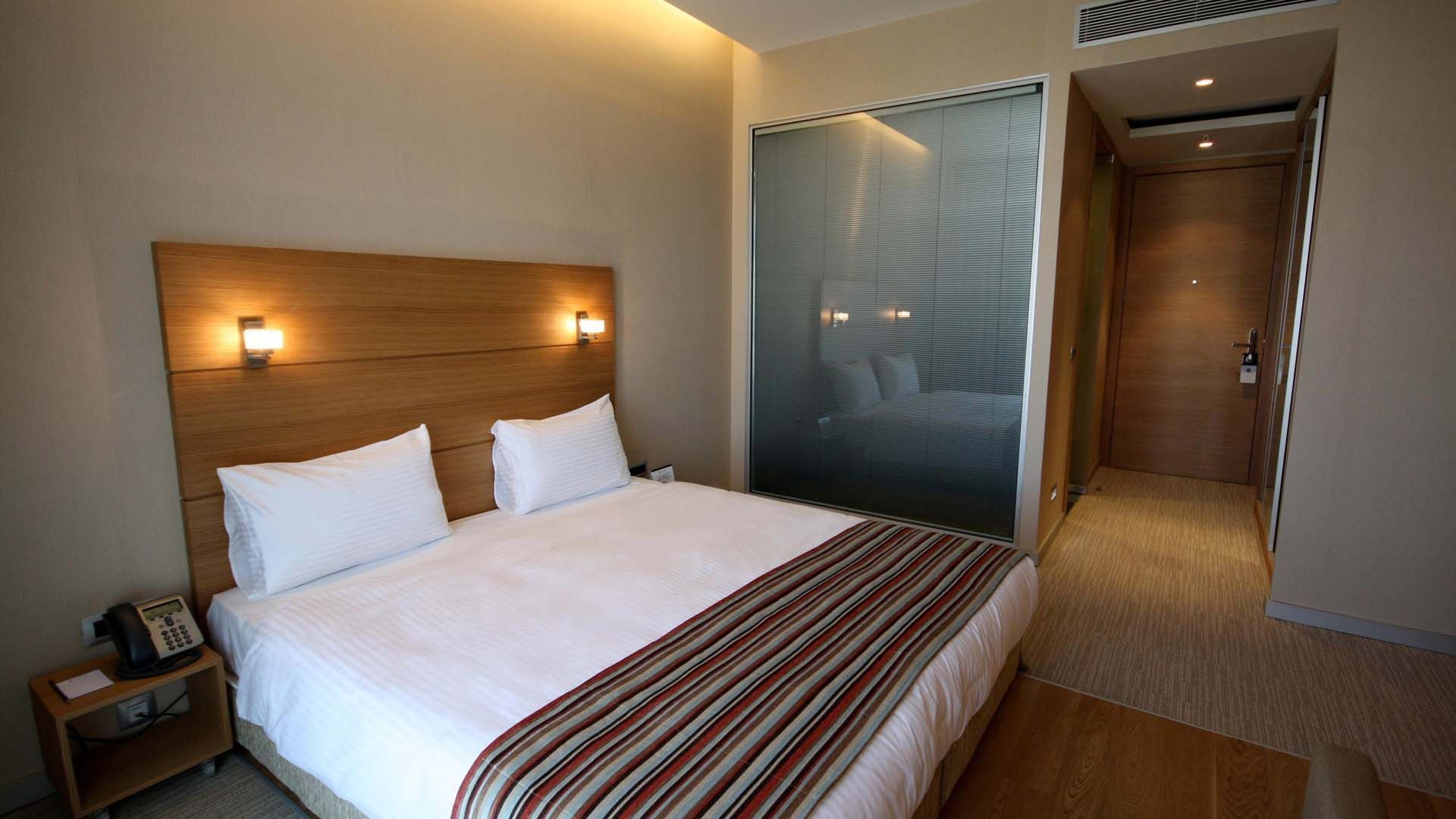 Superior Room with a double bed, side lamps and wooden accents at Titanic Anadolu Gebze
