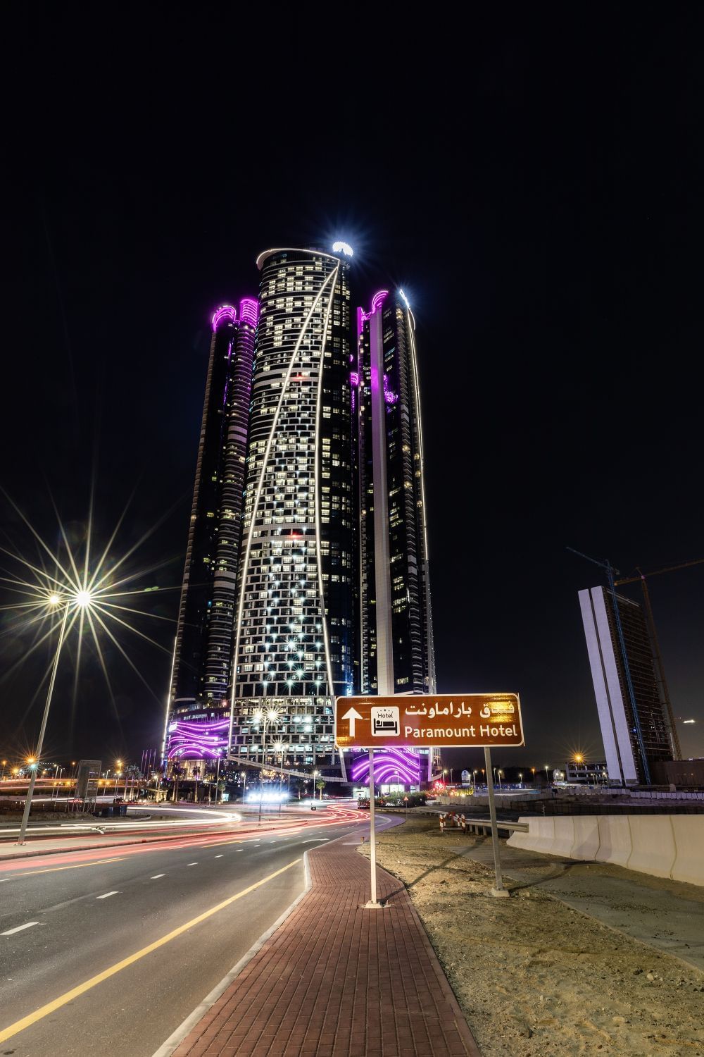 Low-angle exterior view of Paramount Hotel Dubai & street at night
