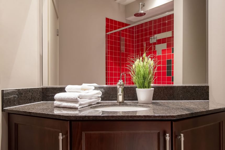 a sink is the focus with folded towels and you can see a bright 
