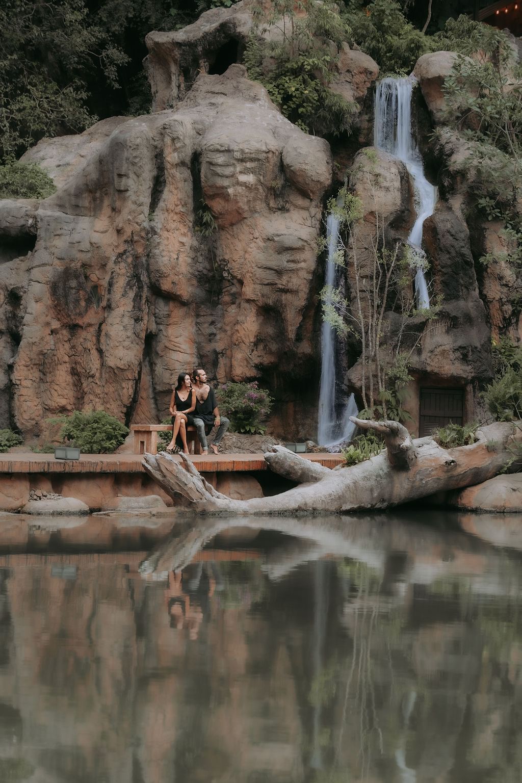 Couple lounging by a mini waterfall at The Banjaran Hotsprings Retreat